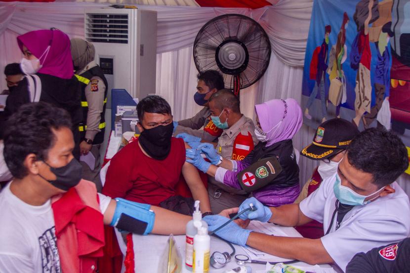 Petugas kesehatan menyuntikkan vaksin COVID-19 kepada pemudik di Pos Pelayanan Ketupat Lodaya 2022, Rest Area KM 57, Karawang, Jawa Barat, Selasa (26/4/2022). Kapolri Jenderal Polisi Listyo Sigit Prabowo mengatakan pihaknya telah menyiapkan gerai vaksinasi COVID-19 dosis penguat untuk melayani pemudik guna mencegah lonjakan kasus COVID-19 setelah libur Idul Fitri 1443 H.