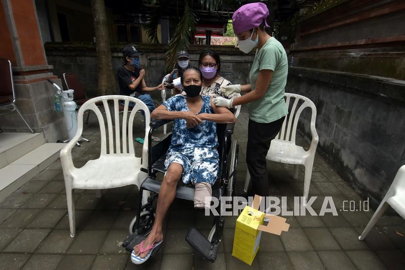 Petugas kesehatan menyuntikkan vaksin COVID-19 kepada penyandang tuna daksa di Rumah Bisabillitas, Denpasar, Bali, Ahad (9/5/2021). Pemerintah Kota Denpasar menggelar vaksinasi bagi penyandang disabilitas yang diikuti 384 orang untuk pencegahan penyebaran COVID-19 sekaligus percepatan Bali bebas COVID-19. 