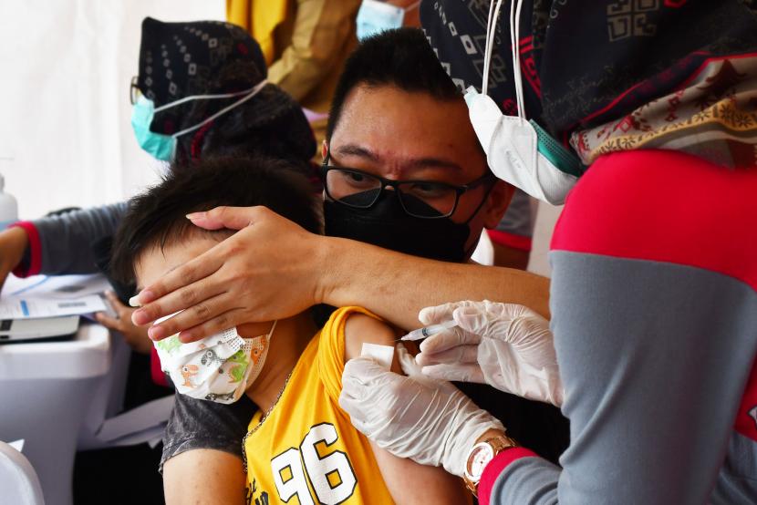 Petugas kesehatan menyuntikkan vaksin Covid-19 kepada seorang anak saat digelar vaksinasi Covid-19 massal di ruang publik kawasan Sumber Wangi, Kota Madiun, Jawa Timur, Senin (14/2/2022). Kemenkes menyatakan, kasus Covid-19 pada anak saat ini cenderung meningkat.