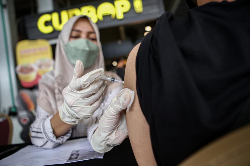 Petugas kesehatan menyuntikkan vaksin COVID-19 kepada warga di Mal Qbig, Pagedangan, Kabupaten Tangerang, Banten, Ahad, (18/9/2022). Realisasi vaksinasi booster kedua di Tangerang Raya baru mencapai 39 ribu orang