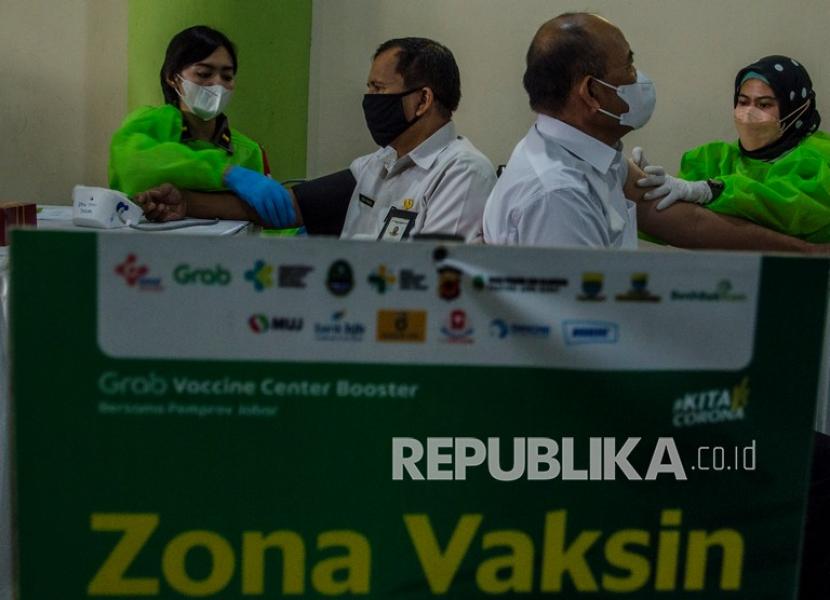 Petugas kesehatan menyuntikkan vaksin COVID-19 ketiga (booster) kepada warga di Vaccine Center Sport Arcamanik, Bandung, Jawa Barat, Rabu (9/2/2022). Sedikitnya 10 ribu warga mulai dari lansia, ASN, dan pengojek daring ditargetkan menerima vaksin booster untuk percepatan kekebalan kelompok dan sebagai antisipasi guna menekan kenaikan kasus harian COVID-19.