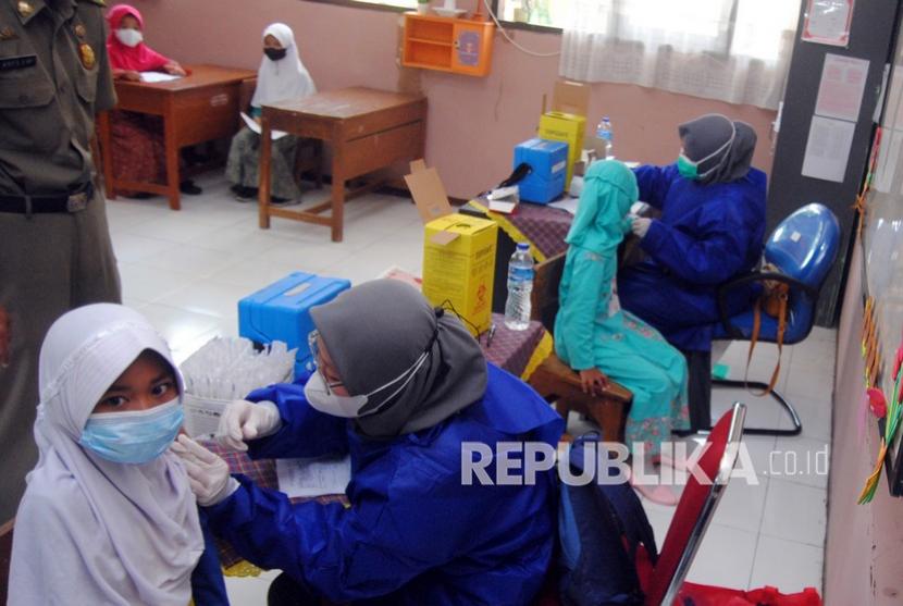 Petugas kesehatan menyuntikkan vaksin COVID-19 pada siswa di SDN Kawung Luwuk, Kota Bogor, Jawa Barat, Rabu (15/12). Pemerintah Kota Bogor mulai melakukan vaksinasi Covid-19 dosis pertama untuk anak usia 6 hingga 11 tahun, termasuk bagi anak-anak putus sekolah.