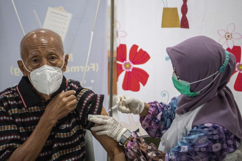 Petugas kesehatan menyuntikkan vaksin dosis ketiga (booster) jenis Pfizer kepada warga di Puskesmas lima Ilir, Palembang, Sumatera Selatan, Kamis (13/1/2022). Dinas Kesehatan Kota Palembang, Sumatera Selatan, mengoptimalkan percepatan vaksinasi penguat atau dosis ketiga sebagai upaya untuk mitigasi penyebaran COVID-19 di kota itu yang sedang mengalami tren peningkatan kasus.