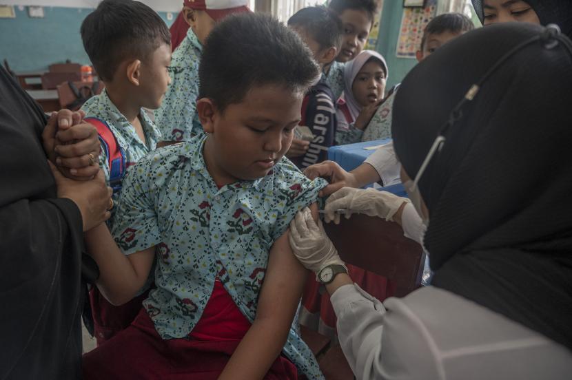 Petugas kesehatan menyuntikkan vaksin kepada murid saat imunisasi anak di SD Inpres Palupi, Palu, Sulawesi Tengah, Rabu (26/10/2022). Imunisasi anak di sekolah itu untuk memperluas cakupan imunisasi dasar anak yang secara nasional sempat turun dari 93 persen pada 2019 menjadi 84,5 persen di 2021 yang disebabkan pandemi COVID-19. 