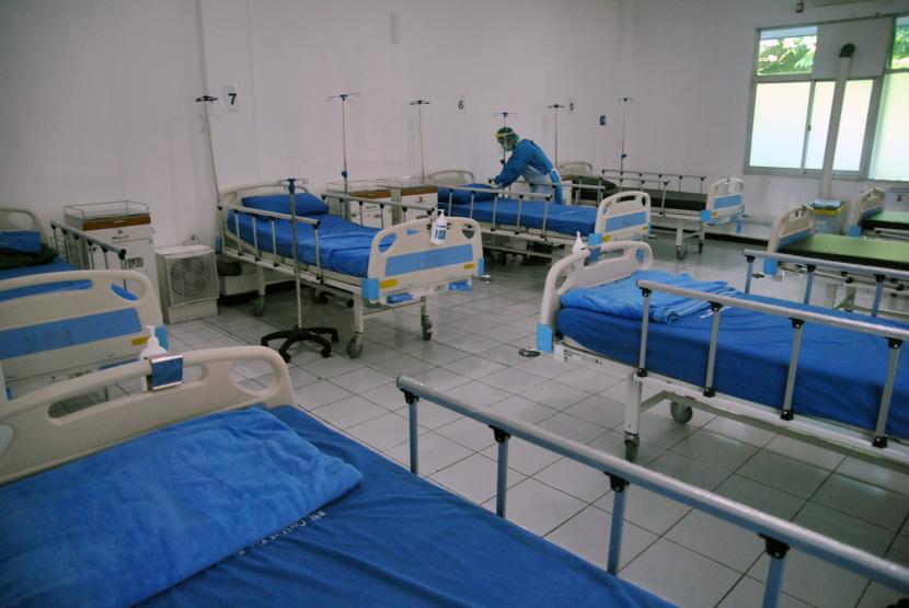 Petugas kesehatan merapihkan tempat tidur di ruang perawatan pasien Covid-19.