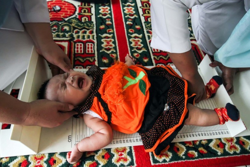 Petugas Kesehatan Puskesmas Muara Dua melakukan pemeriksaan stunting anak meliputi status gizi, berat badan dan tinggi badan di Desa Meunasah Alue, Lhokseumawe, Aceh, Rabu (27/3/2019).