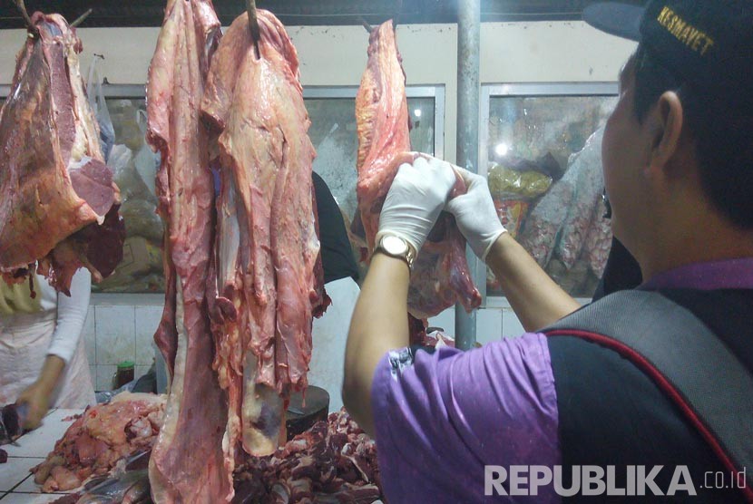 Petugas Kesmavet Dinas Peternakan dan Perikanan Kabupaten Semarang memeriksa daging sapi yang dijual salah seorang pedagang di Pasar Babadan, Kabupaten Semarang, Jawa Tengah, Jumat (3/6) dini hari. (Republika/Bowo Pribadi)