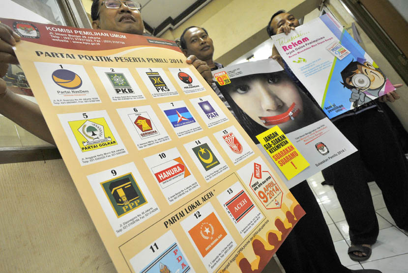   Petugas Komisi Pemilihan Umum (KPU) menunjukkan poster sosialisasi penyelenggaraan Pemilu 2014 di Jakarta, Jumat (7/2).   (Antara/Yudhi Mahatma)
