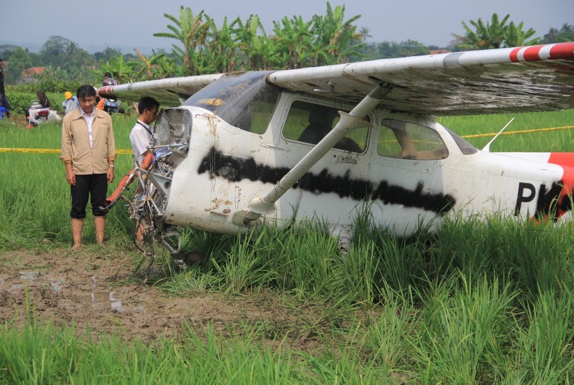 Petugas Komite Nasional Keselamatan Transportasi (KNKT) mengidentifikasi bangkai pesawat Cessna yang jatuh di areal persawahan desa Banjar Wangunan, Mundu, Cirebon, Jawa Barat, Rabu (31/8). 