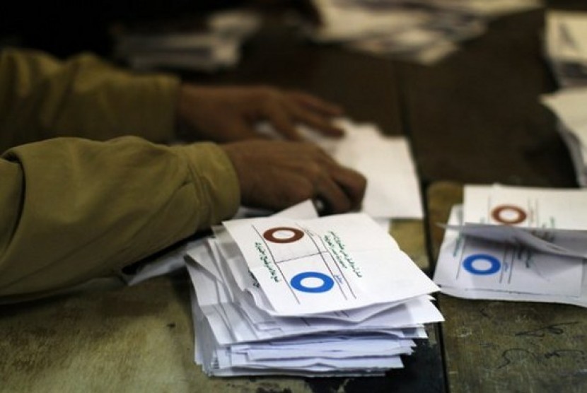 Petugas komite referendum sedang menyortir kertas suara berdasar pilihan 'ya' atau 'tidak' terhadap konstitusi baru Mesir.