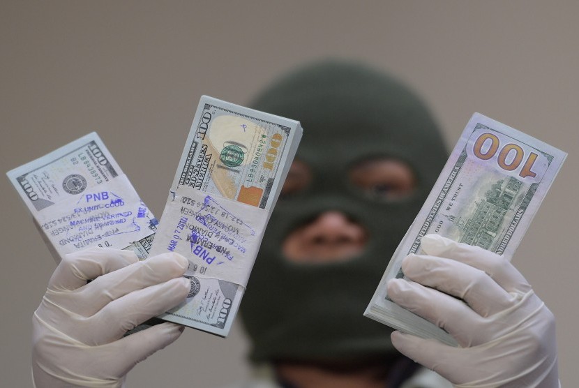 Petugas KPK menunjukkan barang bukti uang dolar AS yang berhasil diamankan dari OTT pejabat PT PAL Indonesia di Kantor KPK, Jakarta, Jumat (31/3). 