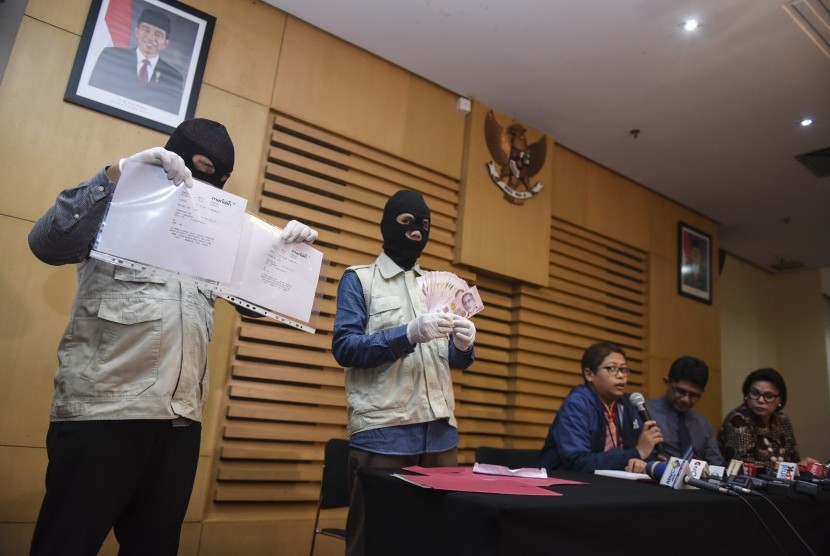 Petugas KPK menunjukkan barang bukti uang Dolar Singapura dan bukti transfer disaksikan dua pimpinan KPK saat konferensi pers terkait operasi tangkap tangan di Gedung KPK, Jakarta, Rabu (29/6). (Antara/Hafidz Mubarak A)