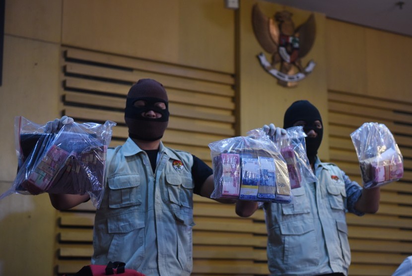 Petugas KPK menunjukkan barang bukti uang saat konferensi pers tentang Operasi Tangkap Tangan KPK di Gedung KPK, Jakarta, Selasa (12/4).