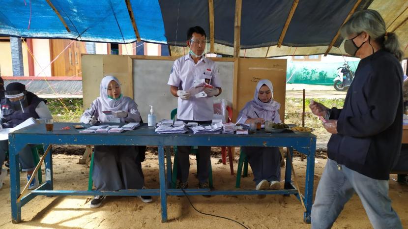 Petugas KPPS di TPS 3 Desa Lamajang Kecamatan Pangalengan Kabupaten Bandung menggunakan seragam sekolah selama proses pengambilan suara pada Rabu (9/12). 