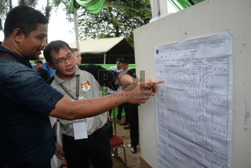 Petugas KPPS (Kelompok Penyelenggara Pemungutan Suara) menghitung kertas suara di TPS 44 Pemilukada Tangsel, Serpong, Tangsel, Rabu (9/12).