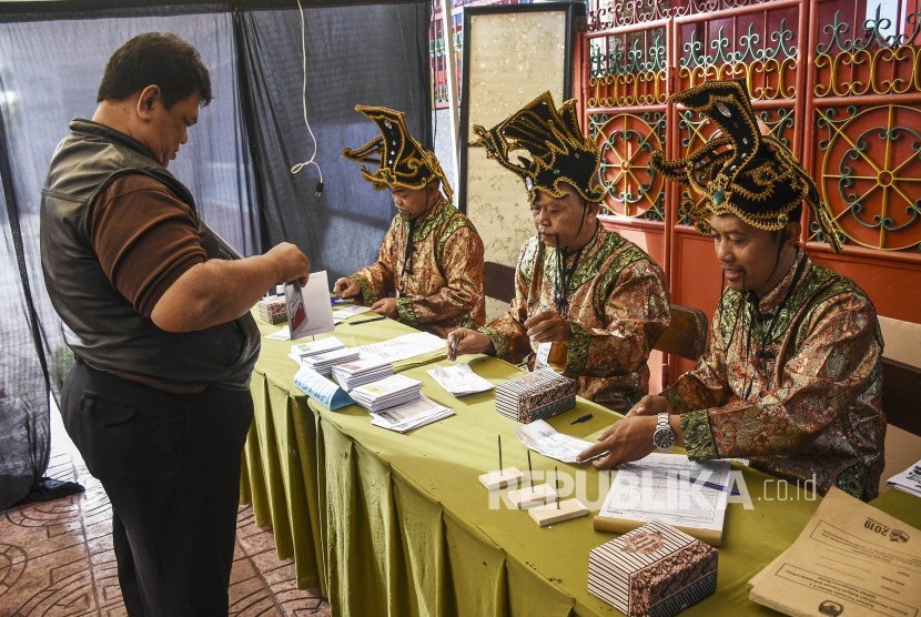 Petugas KPPS membantu warga yang akan memberikan hak suaranya di TPS 005 Pemilu 2019 di Kelurahan Cibadak, Kecamatan Astanaanyar, Kota Bandung, Rabu (17/4).
