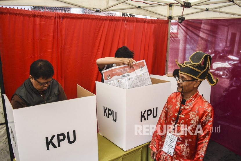 Petugas KPPS membantu warga yang akan memberikan hak suaranya di TPS 005 Pemilu 2019 di Kelurahan Cibadak, Kecamatan Astanaanyar, Kota Bandung, Rabu (17/4).