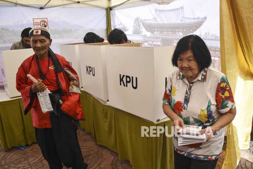 Petugas KPPS membantu warga yang akan memberikan hak suaranya di TPS 004 Pemilu 2019 di Kelurahan Cibadak, Kecamatan Astanaanyar, Kota Bandung, Rabu (17/4).