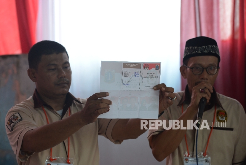 Petugas KPPS menunjukkan surat suara.