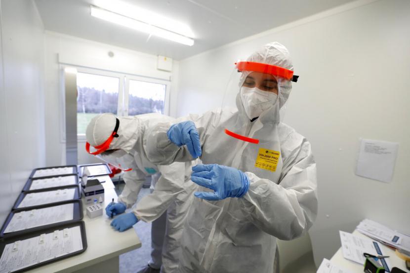 Petugas lab bekerja dengan cairan antigen di Praha, Republika Ceko. Pemerintah Ceko akan mengizinkan para pekerja medis dan layanan sosial untuk tetap pergi menjalankan tugas meskipun mereka sedang mengidap COVID-19.