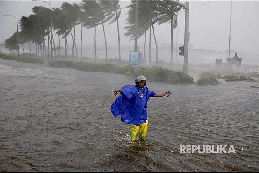 Petugas lalulintas menutup jalanan yang dilanda banjir akibat terpaan badai di Manila, Filipina, ilustrasi