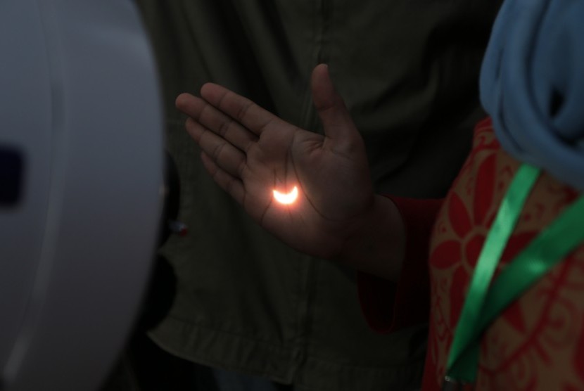 Petugas Lapan menunjukkan pantulan cahaya saat mengamati Gerhana Matahari Total (GMT) dengan menggunakan teleskop di atas Jembatan Ampera Palembang, Sumatera Selatan, Rabu (9/3).