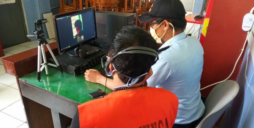 Petugas Lapas Kelas II B Tasikmalaya mengarahkan seorang warga binaan melalukan video call, Kamis (23/4).