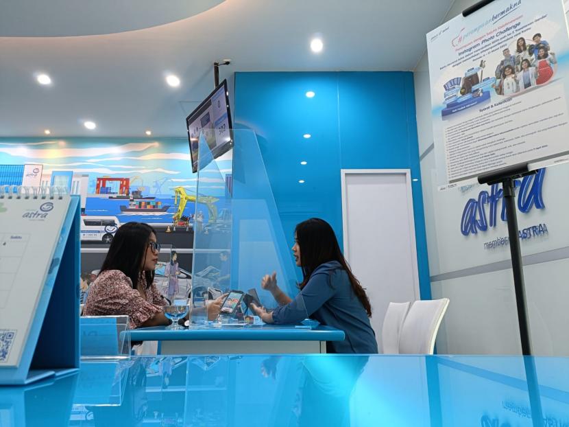Petugas layanan pelanggan memberikan penjelasan terkait penggunaan aplikasi Asuransi Astra di Jakarta, Selasa (7/3/2023). 