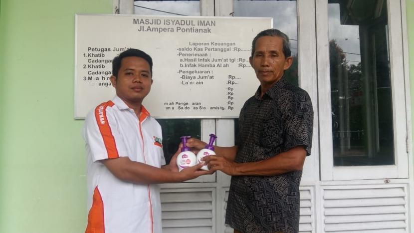 Petugas Laznas BMH menyerahkan bantuan  hand sanitizer dan hand wash kepada pengurus Masjid Irsyadul Iman, Pontianak.