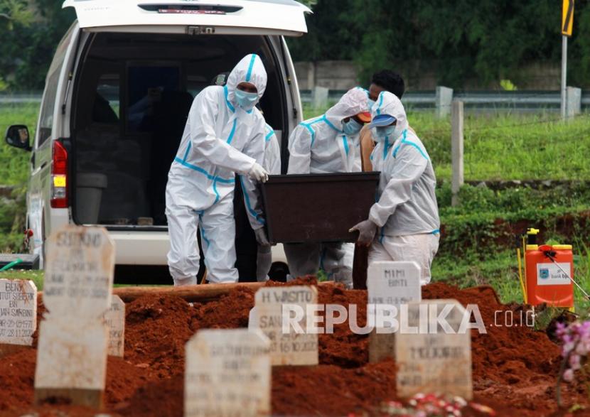 Petugas makam membawa jenazah saat akan dimakamkan di TPU khusus Covid-19 Jombang, Tangerang Selatan, Banten. Jumlah jenazah Covid yang dimakamkan di TPU ini melonjak 100 persen lebih.