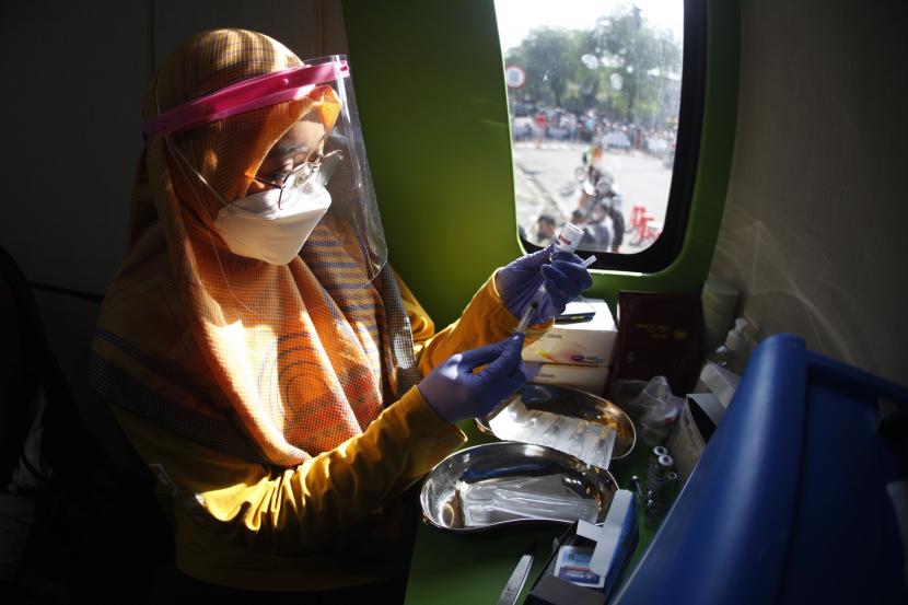 Petugas medis bersiap menyuntikkan vaksin booster pada warga saat pelaksanaan layanan Mobil Keliling Vaksinasi COVID-19 di kawasan Ngarsopuro, Solo, Jawa Tengah, Ahad (15/5/2022). Vaksinasi booster di Kota Solo telah memenuhi target 52 persen dan merupakan yang tertinggi di seluruh Jawa Tengah.