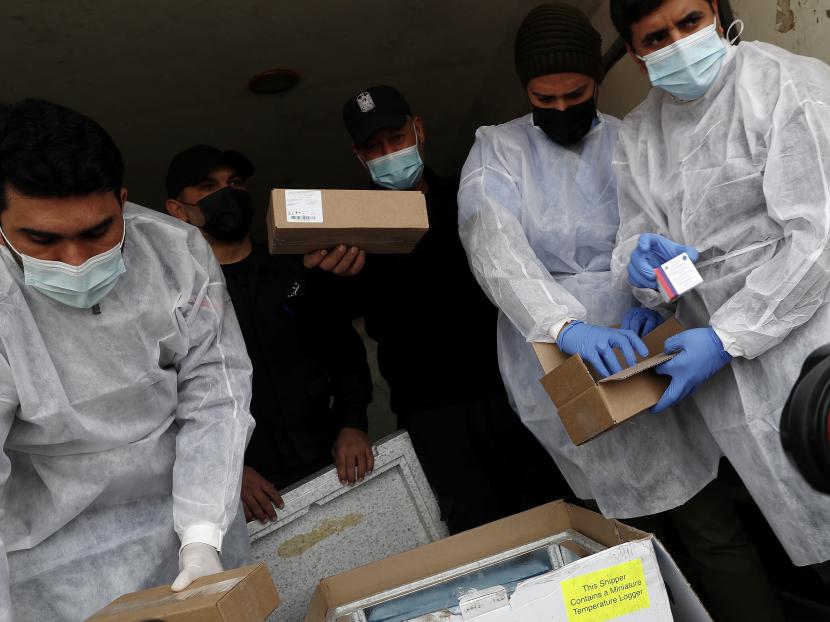 Petugas medis dan polisi memeriksa pengiriman vaksin Sputnik V Rusia di dalam truk di perlintasan perbatasan Kerem Shalom, di Rafah, Jalur Gaza, Rabu, 17 Februari 2021. Rencana vaksinasi Covid-19 di Palestina menghadapi kekurangan dana 30 juta dolar AS.