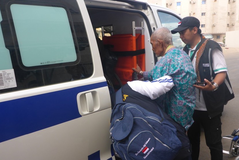 Ilustrasi. Petugas medis KKHI membantu jamaah haji masuk ke ambulans.
