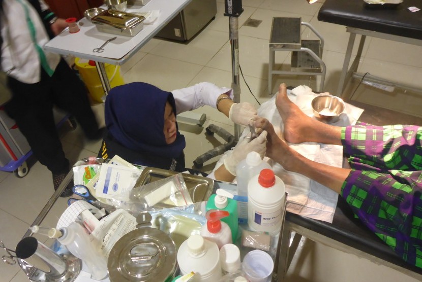 Petugas medis KKHI Madinah mengobati luka pada kaki jamaah haji Indonesia di KKHI Madinah, Al Aridh, Arab Saudi.
