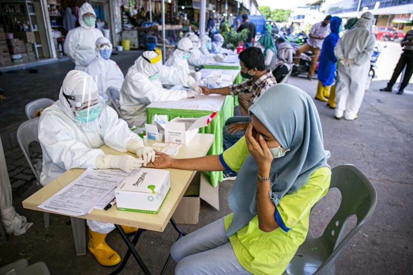 Petugas medis melakukan pemeriksaan cepat (rapid test) COVID-19 terhadap sejumlah pedagang di Pasar Botania 2, Batam, Kepulauan Riau, Jumat (15/5/2020). Pemeriksaan ini dilakukan untuk mencegah penyebaran COVID-19 di sejumlah pasar tradisional. 