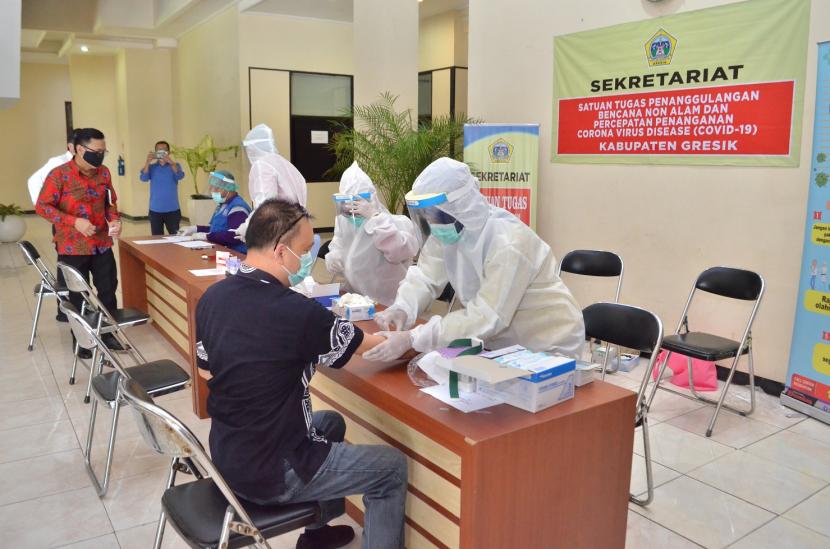 Petugas medis melakukan protokol kesehatan dalam menjalankan tes cepat ke warga Kabupaten Gresik. Jumlah tambahan pasien sembuh dari COVID-19 di Kabupaten Gresik, Jawa Timur, kini lebih tinggi dibandingkan dengan tambahan pasien terkonfirmasi atau positif, yakni mencapai 31 orang, sedangkan positif 30 orang.