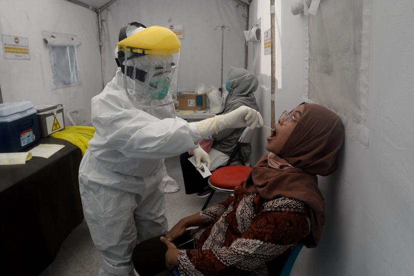 Petugas medis melakukan tes usap atau swab test terhadap warga di Puskesmas Kecamatan Gambir, Jakarta.