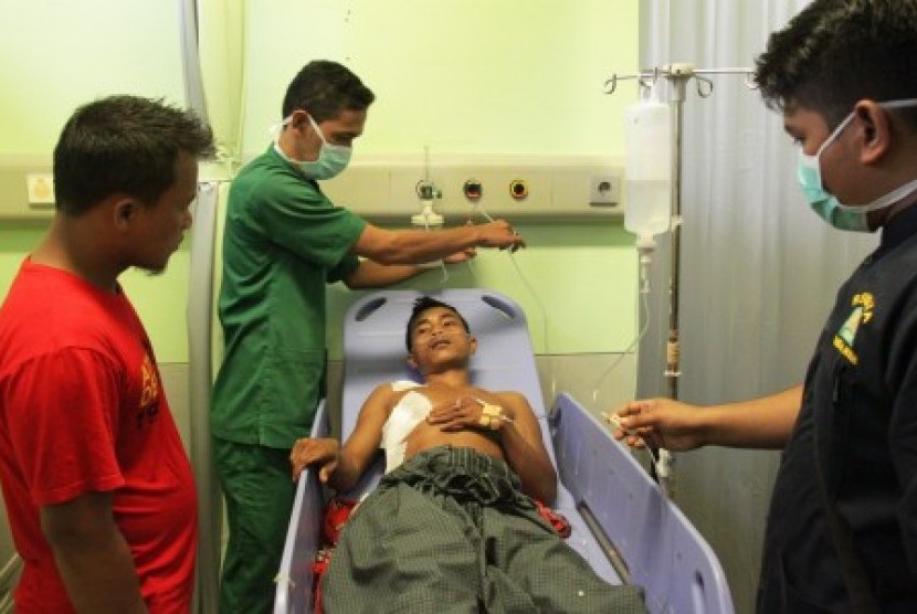Petugas medis memasang infus pada pasien Uyung (27), korban tembak pada konflik di Aceh Singkil, saat dirujuk di Rumah Sakit Umum Zainal Abidin, Banda Aceh, Rabu (14/10). 