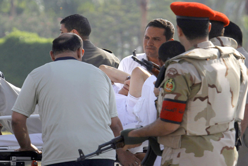 Petugas medis membawa mantan Presiden Mesir Husni Mubarak, masuk ke dalam ambulans setelah setelah ia diterbangkan  melalui helikopter dari penjara Tora ke Rumah Sakit militer Maadi di Kairo, Kamis (22/8). (AP/Amr Nabil)