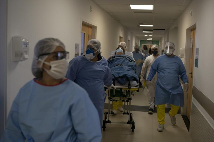 Petugas medis membawa seorang pasien virus corona di Rumah Sakit Dr. Ernesto Che Guevara di Marica, Brasil, Kamis (21/5).