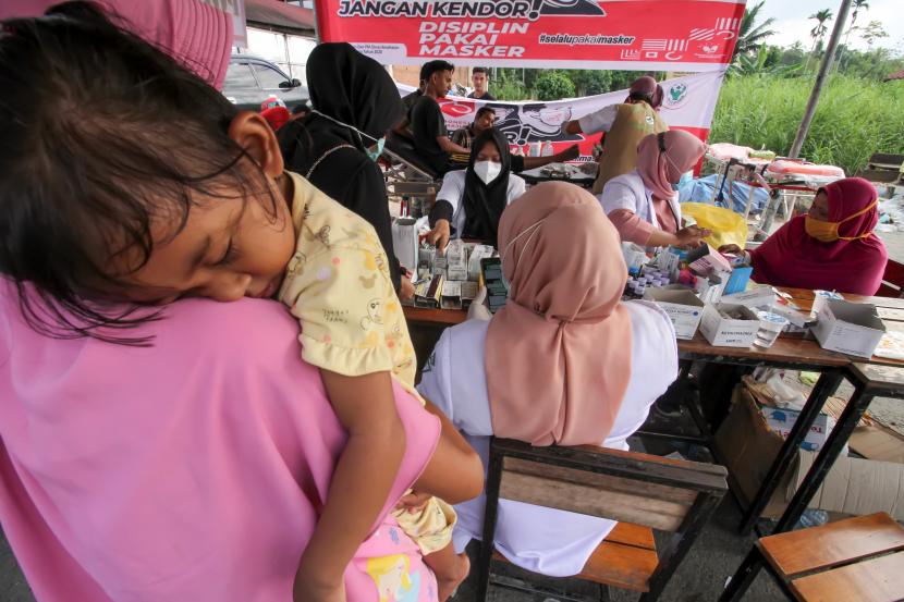 Petugas medis memeriksa kesehatan pengungsi banjir di posko kesehatan Lhoksukon, Aceh Utara, Aceh, Selasa (8/12/2020). Pengungsi banjir mulai diserang penyakit seperti, flu dan batuk, demam, gatal-gatal, dehidrasi dan kurang darah (anemia).