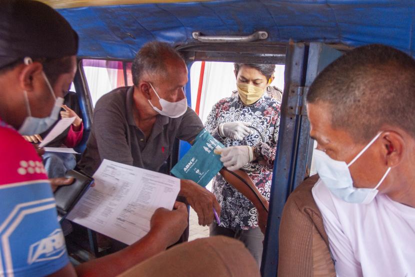 Petugas medis memeriksa kesehatan warga sebelum menerima vaksin COVID-19 secara drive thru di Karawang, Jawa Barat, Selasa (24/8/2021). Polres Karawang memberikan vaksinasi COVID-19 secara drive thru dengan target 150 dosis vaksin per hari sebagai Bhakti Kesehatan Bhayangkara untuk negeri guna menekan lonjakan kasus COVID-19 di Indonesia.