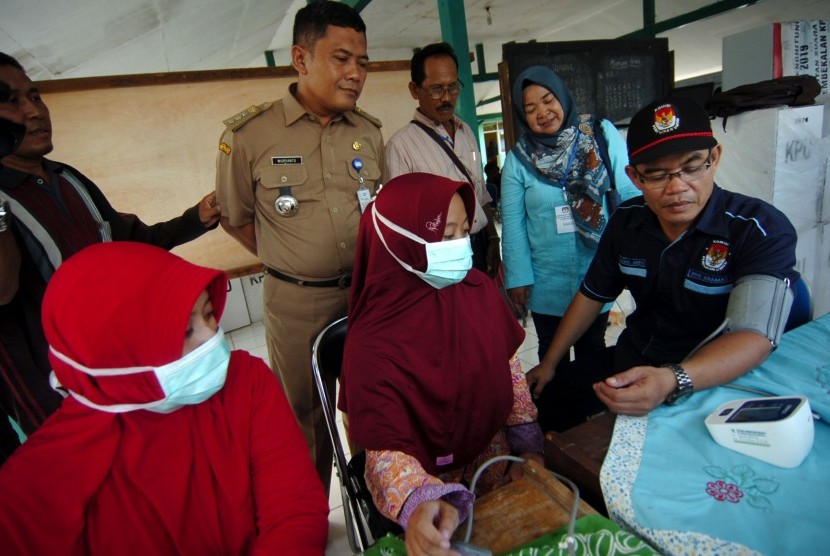 Ilustrasi petugas medis memeriksa kondisi kesehatan anggota penyelenggara Pemilu 2019.