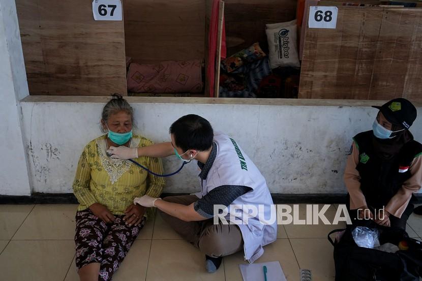 Petugas medis memeriksa kondisi kesehatan seorang lansia. Di Indonesia lansia belum akan masuk kelompok penerima vaksin Sinovac.