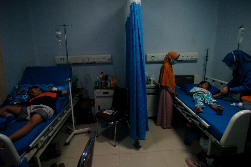 Petugas medis memeriksa kondisi pasien anak penderita Demam Berdarah Dengue (DBD), ilustrasi