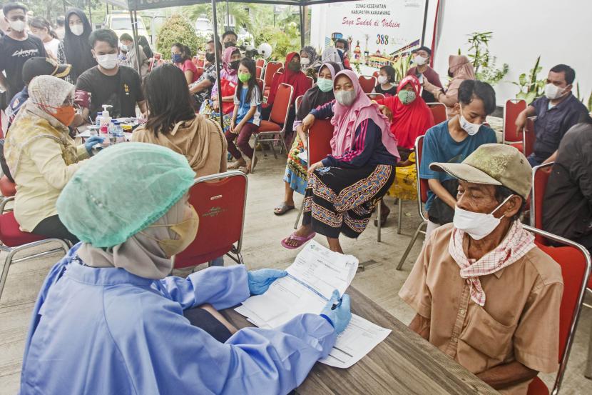Petugas medis memeriksa riwayat kesehatan warga sebelum menerima vaksin COVID-19 di Dinas Kesehatan Karawang, Jawa Barat, Jumat (11/2/2022). Menteri Koordinator Bidang Perekonomian Airlangga Hartarto mengatakan program vaksinasi COVID-19 dosis ketiga sudah dilaksanakan kepada 3,5 persen atau sekitar 6,3 juta penerima dari sasaran usia dewasa sebanyak 181,5 juta penerima