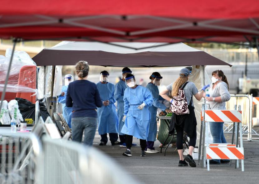 Petugas medis memeriksa warga di tempat penampungan sementara yang didirikan di lahan parkir di Las Vegas. Pemerintah AS berpacu membangun RS darurat di dekat kota besar untuk pasien corona.