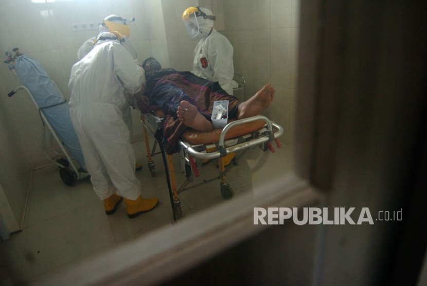 Petugas medis menangani pasien diduga terjangkit corona (ilustrasi).