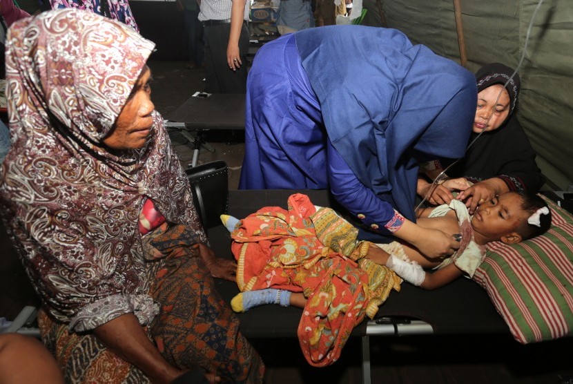 Petugas medis menangani seorang anak korban gempa di Rumah Sakit Umum Daerah (RSUD) Tgk Chik Ditiro Sigli di Pidie, Aceh, Rabu (7/12).