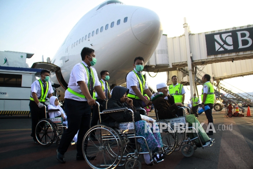Petugas medis mendorong kursi roda jemaah haji yang sakit saat tiba di tanah air di Bandara Internasional Juanda Surabaya di Sidoarjo, Jawa Timur